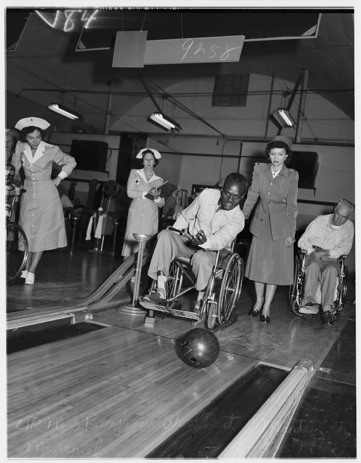 Veterans bowl at the West Los Angeles Veterans Administration as nurses look on.