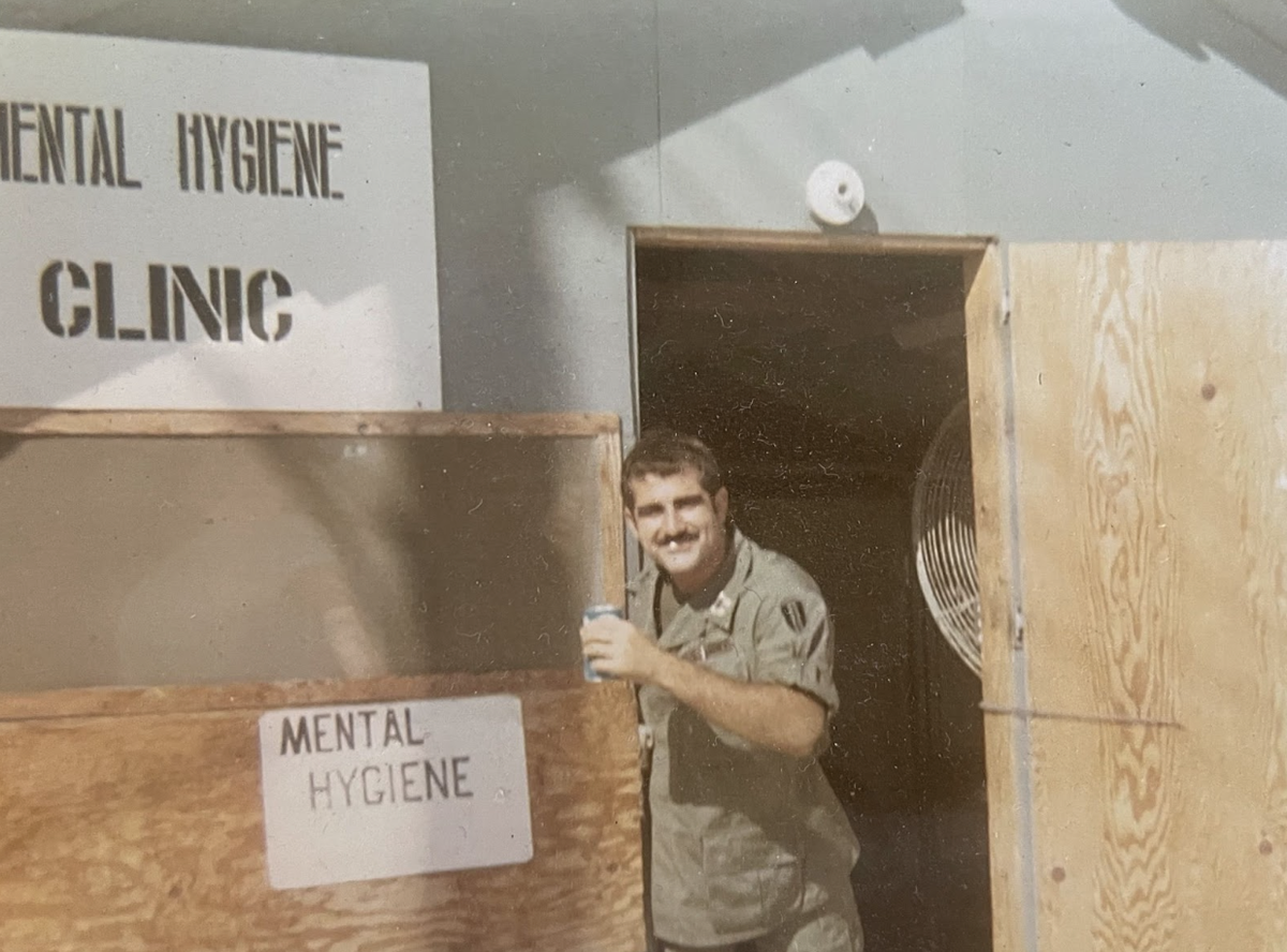 Shad Meshad posing in the doorway of a building labeled "Mental Hygiene Clinic."