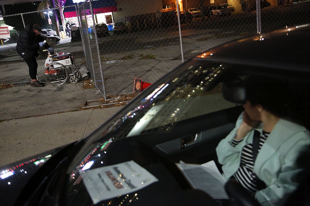 A person in a car looks out the window at a homeless person as they help with Brentwood's first-ever homeless count.