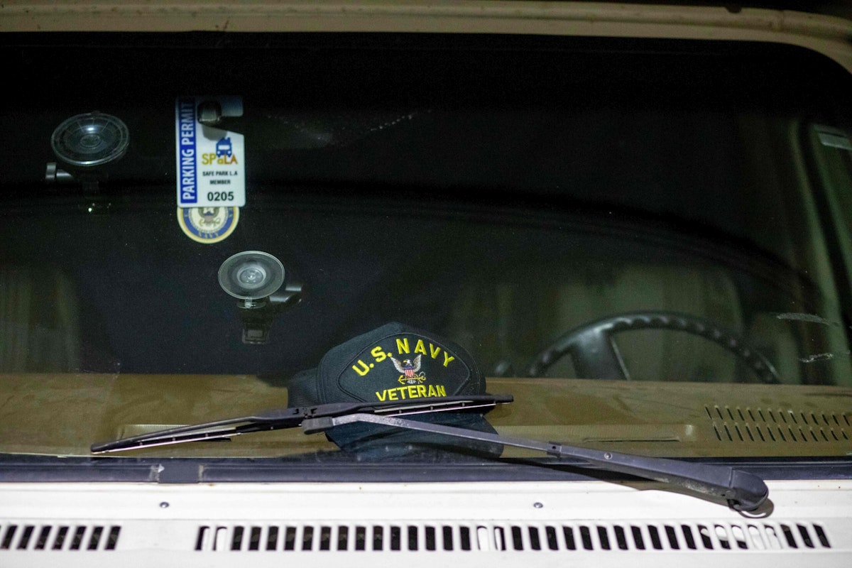 A U.S. Navy veteran hat is seen in the windshield of a camper in the Safe Park LA parking lot near the Veterans Affairs Los Angeles Healthcare Center.