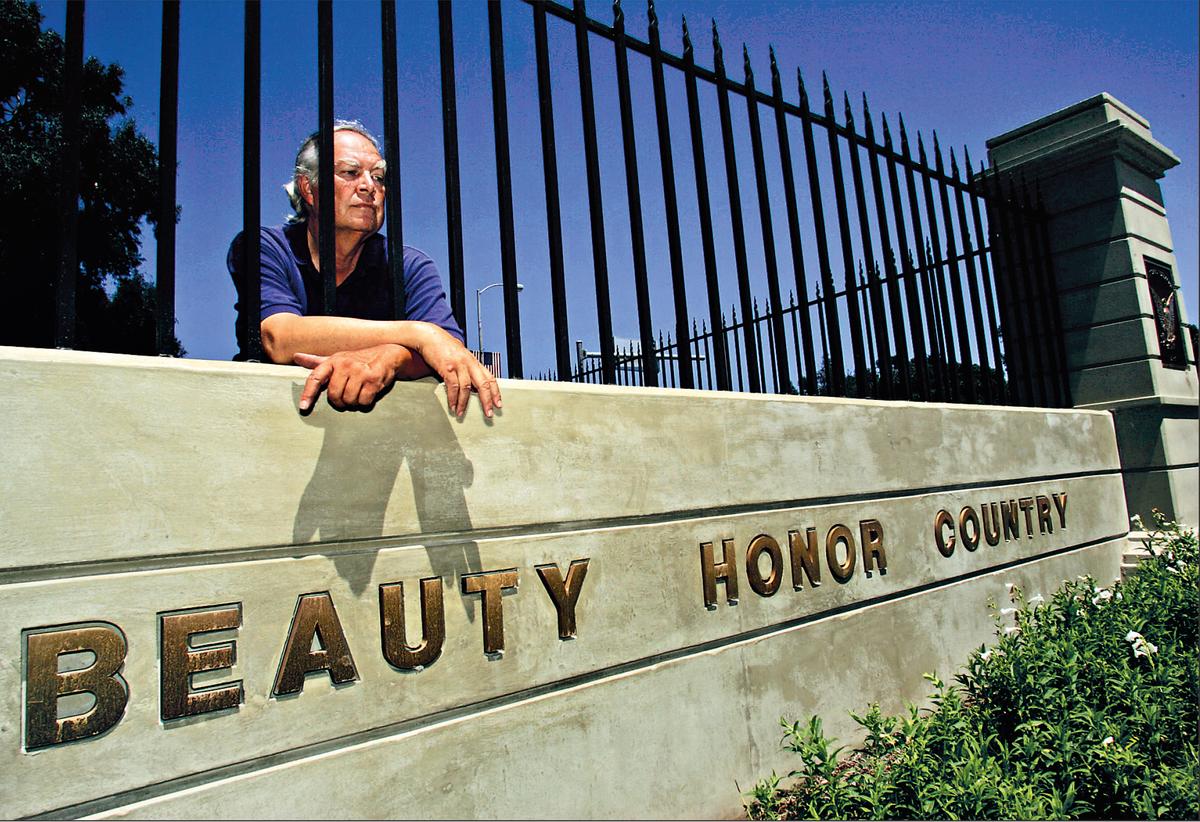 Veteran Robert Rosebrock leans over a wall at the West LA VA that reads “Beauty, Honor, Country.”