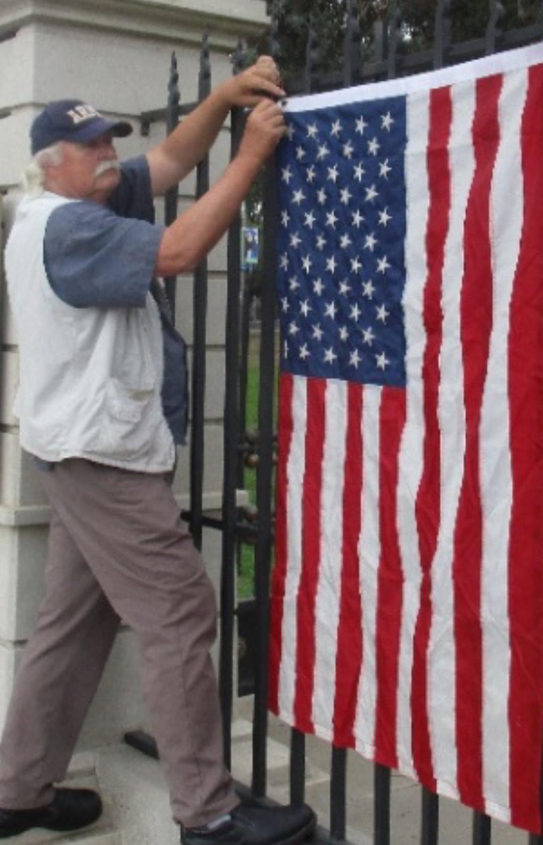 Rosebrock hangs an American flag on the exterior gate of the VA.