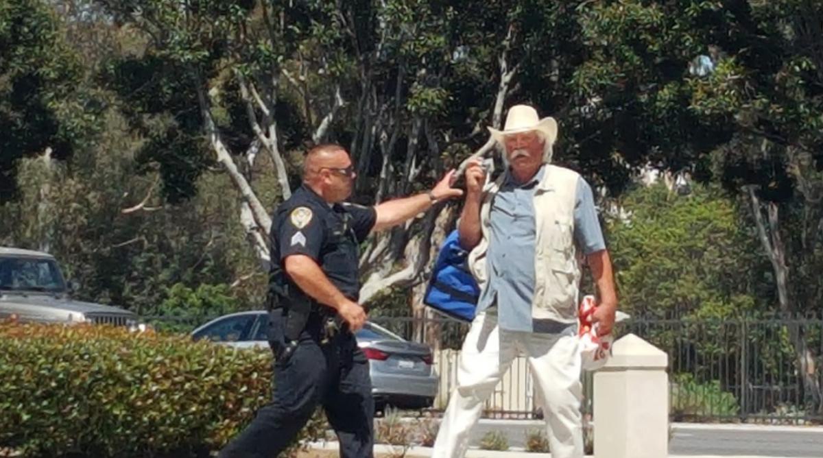 A VA police officer grabs Rosebrock's camera and arrests him for “taking photographs without permission.”