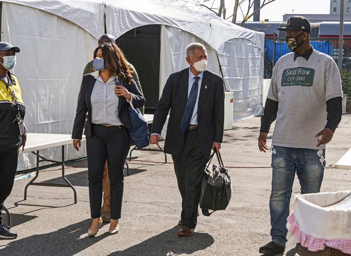 Jeff Page, right, also known as General Jeff, a homelessness activist, walks with U.S. District Court Judge David Carter, middle, and Michele Martinez, special master on the issues of homelessness, after a court hearing in Los Angeles.