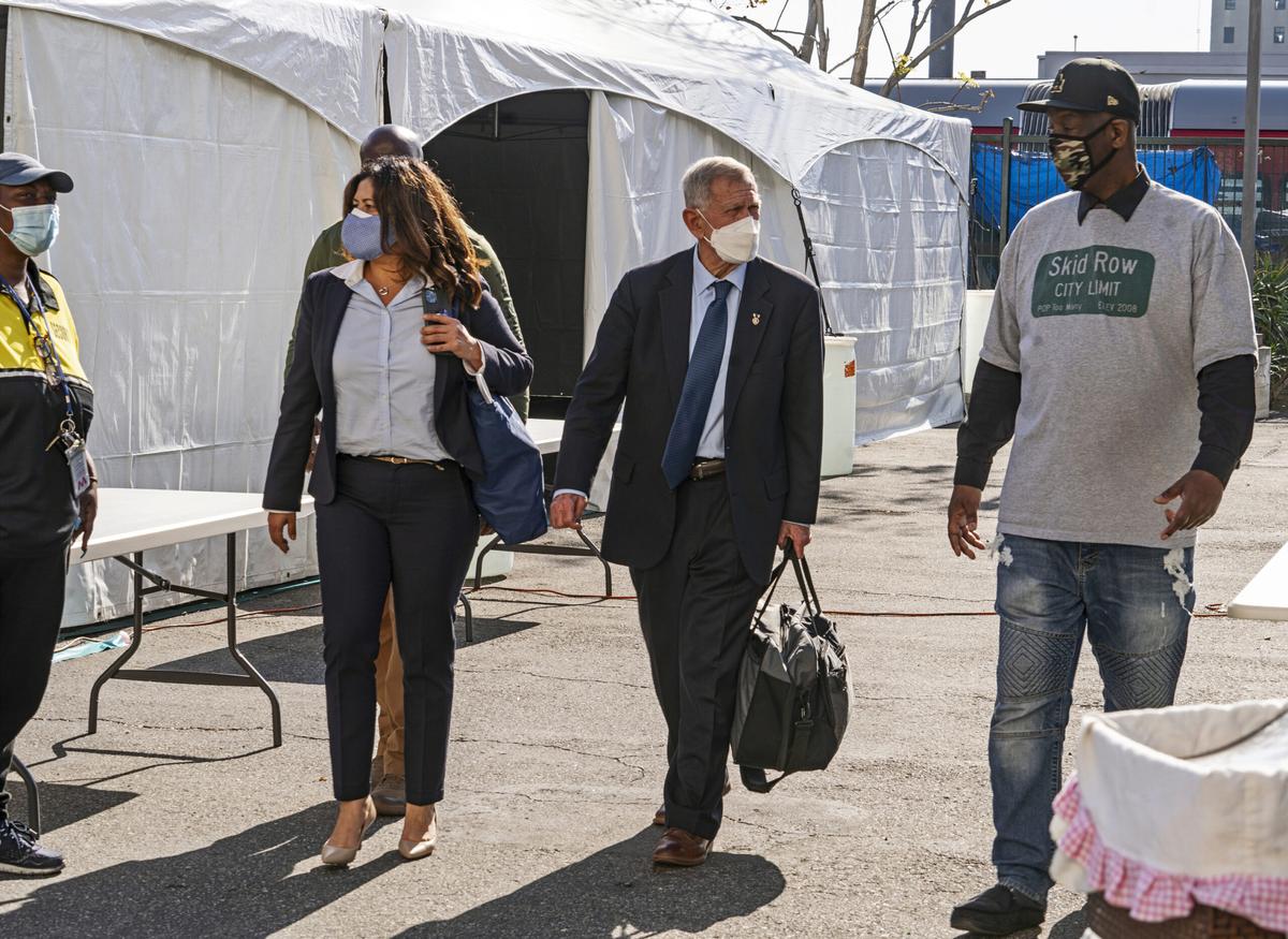 Jeff Page, right, also known as General Jeff, a homelessness activist, walks with U.S. District Court Judge David Carter, middle, and Michele Martinez, special master on the issues of homelessness, after a court hearing in Los Angeles.